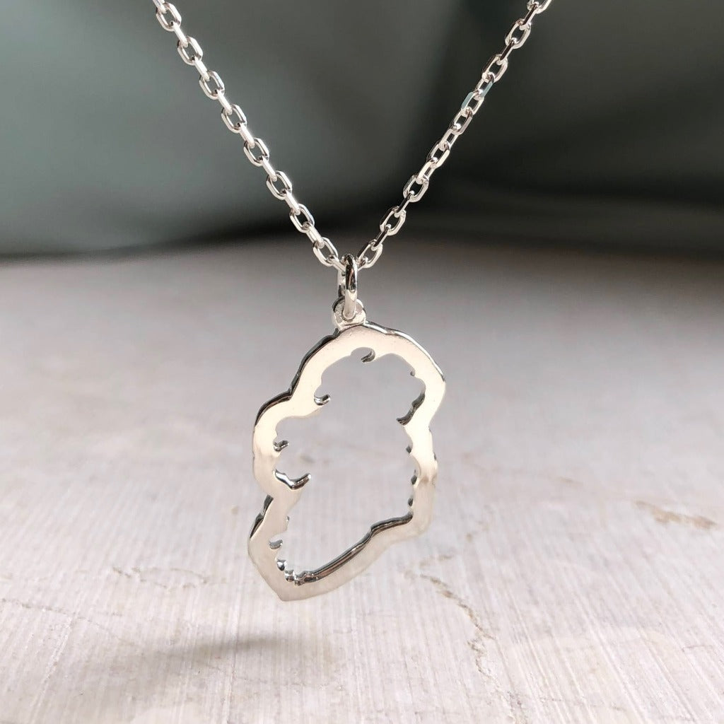 a sterling silver Map of Ireland Necklace with a green silk background