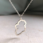 a sterling silver Map of Ireland Necklace with a green silk background