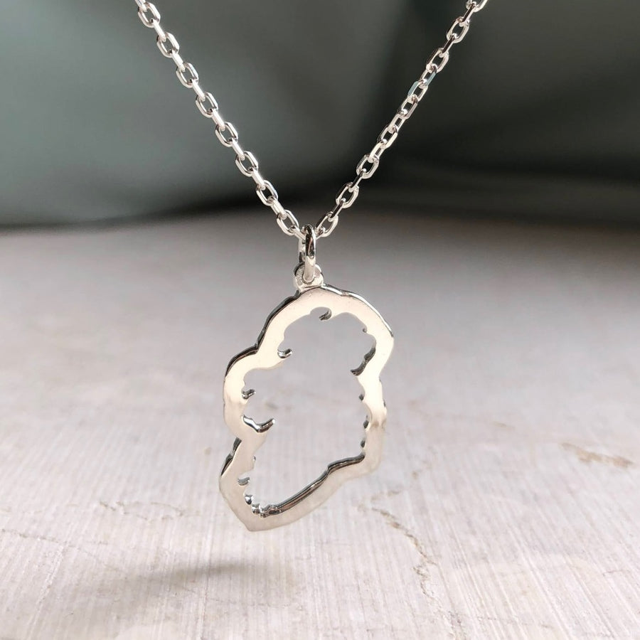 a sterling silver Map of Ireland Necklace with a green silk background
