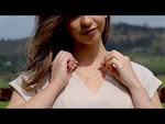 dara knot sterling silver necklace on a model with a field in the background