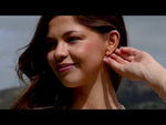 a video of sterling silver drop earrings on a woman's ear